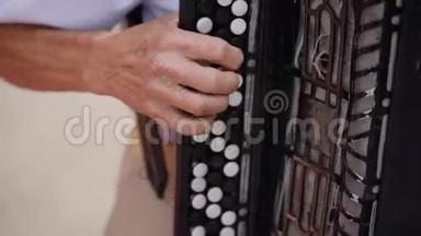 在一个<strong>周年庆</strong>典上，一位老人演奏黑色手风琴的手被特写。